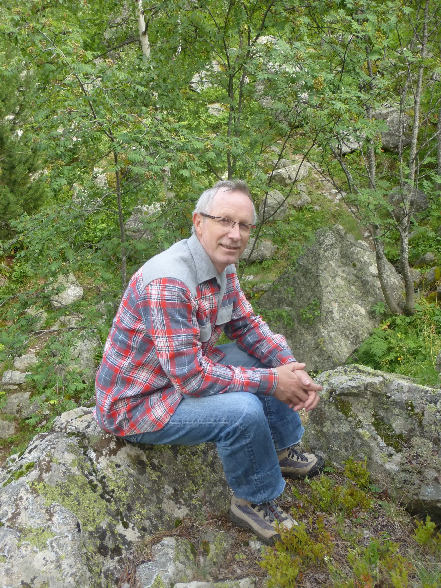 René Lamey assis sur un rocher dans la forêt
